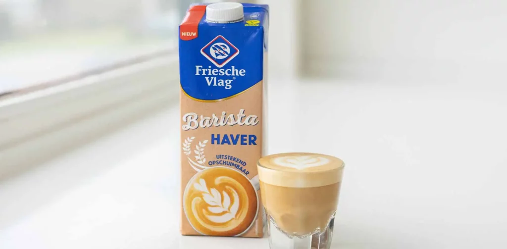 Pak barista haver van Friesche vlag met een cappuccino ernaast