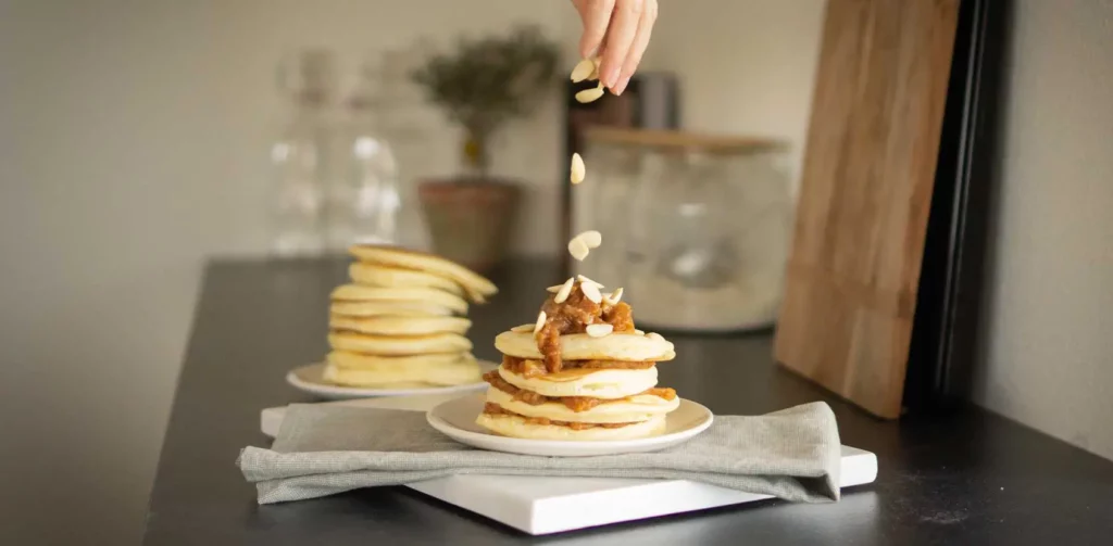 Pancakes met amandel en gekarameliseerde appel op een stapel